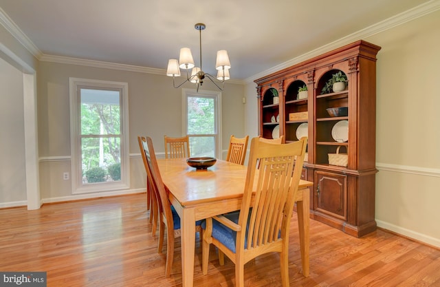 dining area featuring light wood-style flooring, a chandelier, baseboards, and crown molding
