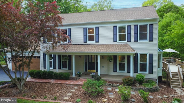 view of front facade featuring covered porch and roof with shingles