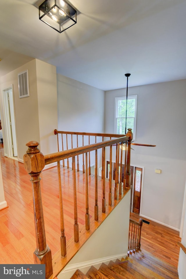 stairs with wood finished floors and baseboards