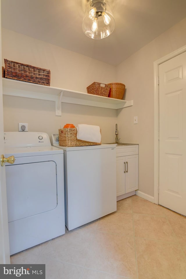 laundry room with washing machine and dryer, cabinet space, and light tile patterned flooring