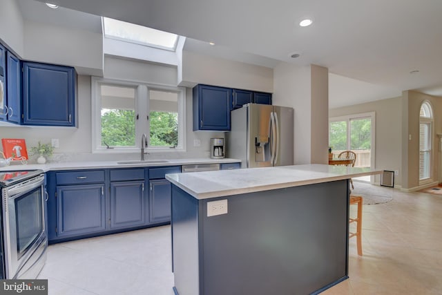kitchen with appliances with stainless steel finishes, a sink, blue cabinetry, light countertops, and recessed lighting