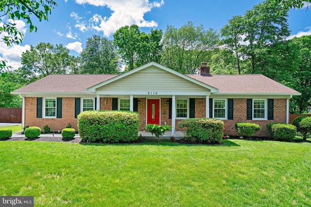 ranch-style home featuring a chimney, covered porch, brick siding, and roof with shingles