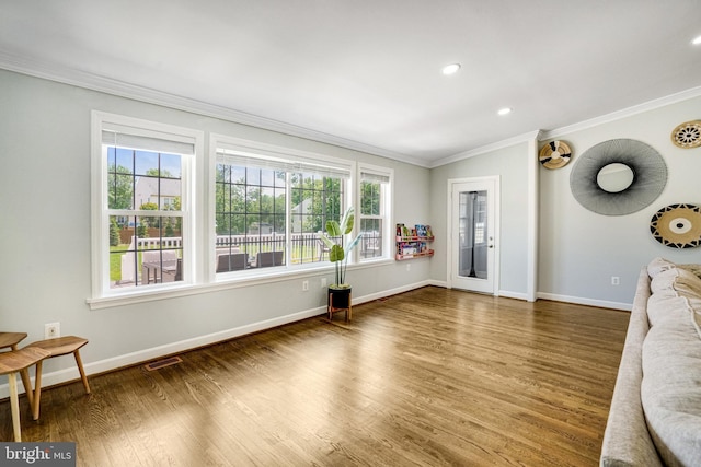 unfurnished living room featuring crown molding, healthy amount of natural light, baseboards, wood finished floors, and recessed lighting