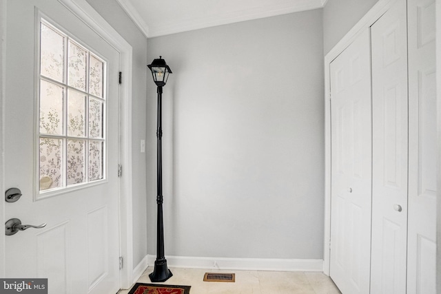 doorway featuring baseboards and crown molding