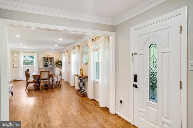 foyer featuring light wood-type flooring, recessed lighting, ornamental molding, and baseboards
