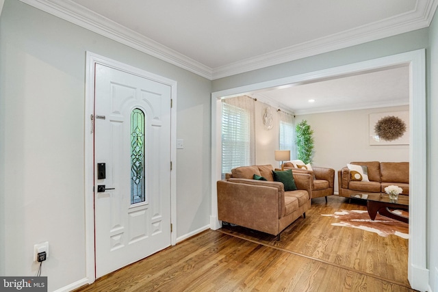 entryway featuring light wood-style flooring, ornamental molding, and baseboards