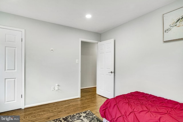 bedroom with wood finished floors, recessed lighting, and baseboards