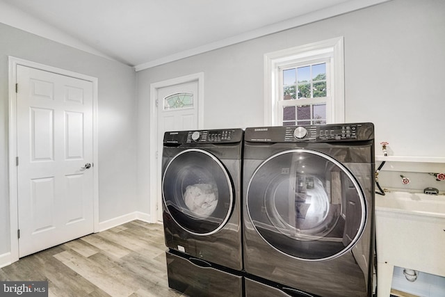 washroom featuring independent washer and dryer, wood finished floors, and baseboards