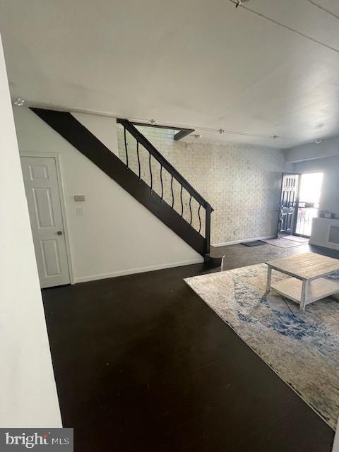 2557 Tilton St, Philadelphia, PA 19125 - living area with stairs, finished concrete flooring, and baseboards