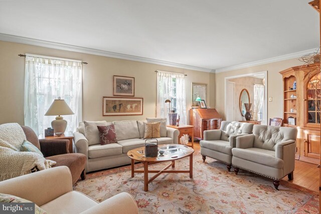 living area featuring light wood-type flooring, ornamental molding, and plenty of natural light
