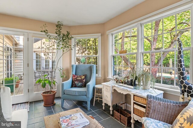 sunroom / solarium featuring french doors, healthy amount of natural light, and tile patterned flooring