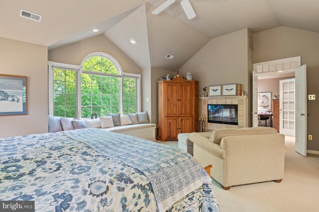 carpeted bedroom with vaulted ceiling, ceiling fan, and a fireplace