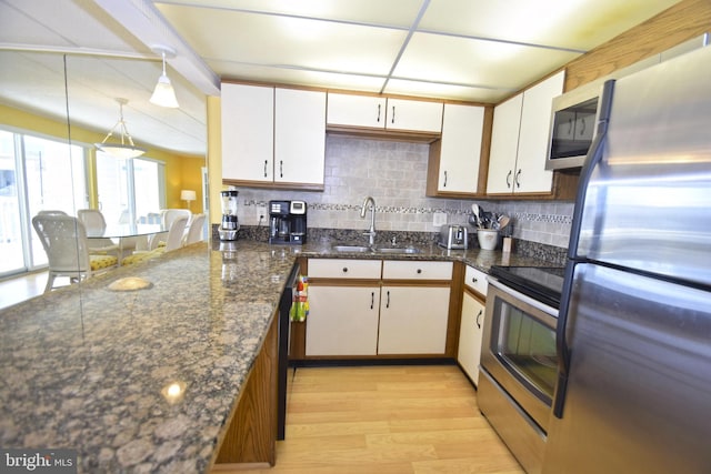 107 Convention Center Dr Unit 148D, Ocean City, MD 21842 - kitchen with appliances with stainless steel finishes, light wood-style floors, decorative backsplash, white cabinetry, and a sink
