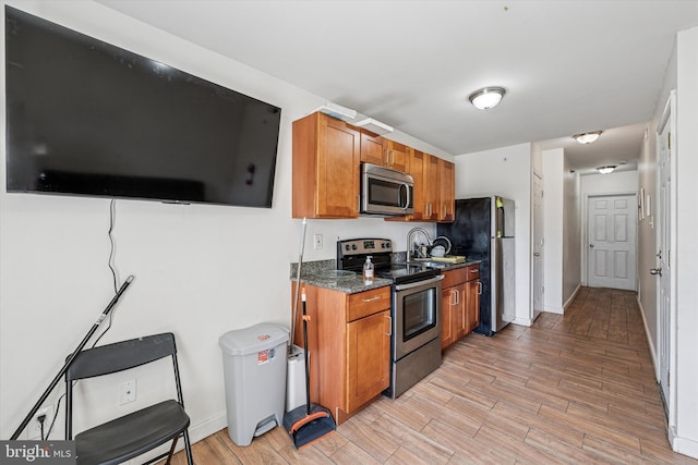 1934 Cecil B Moore Ave, Philadelphia, PA 19121 - kitchen featuring appliances with stainless steel finishes, brown cabinetry, light wood-style floors, and a sink