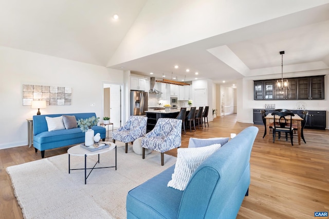 living area featuring light wood finished floors, recessed lighting, baseboards, and a towering ceiling