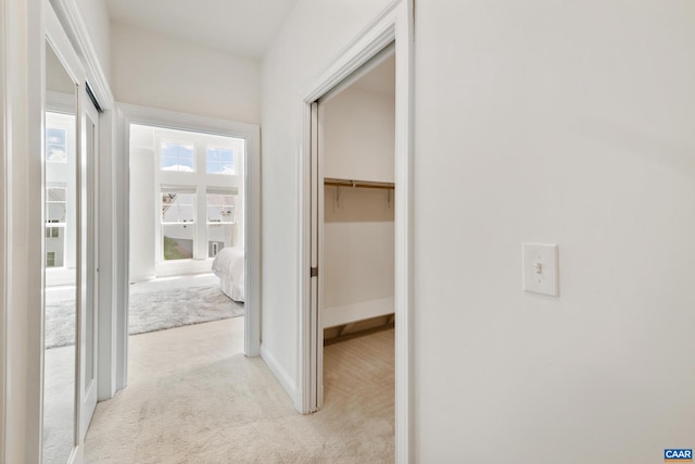corridor with light colored carpet and baseboards