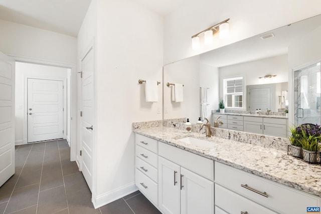 full bath with tile patterned flooring, baseboards, and vanity
