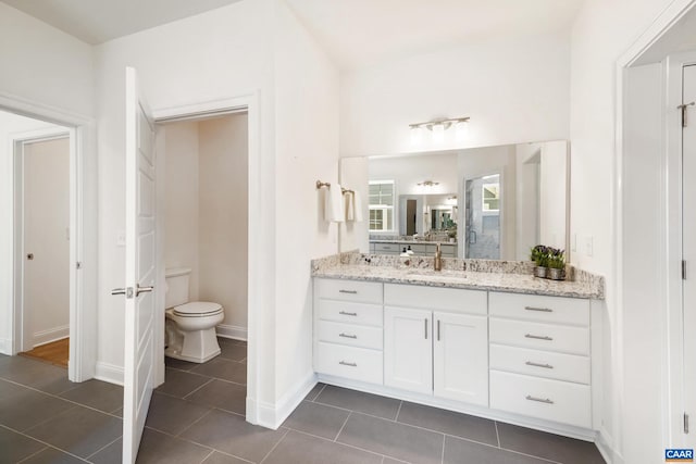 full bathroom featuring toilet, tile patterned flooring, vanity, and baseboards