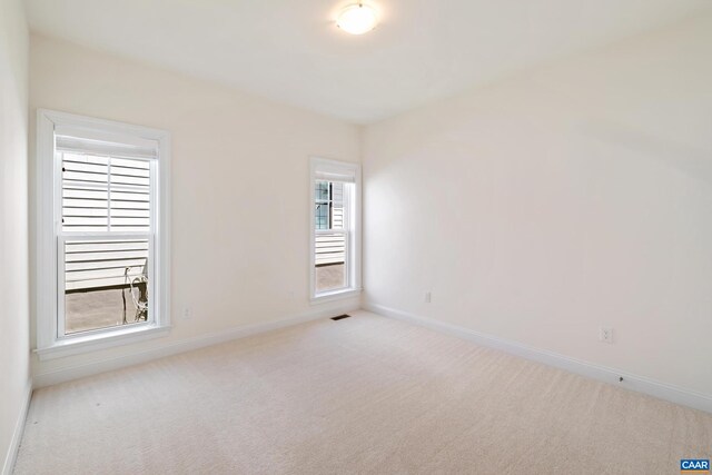 carpeted empty room featuring baseboards