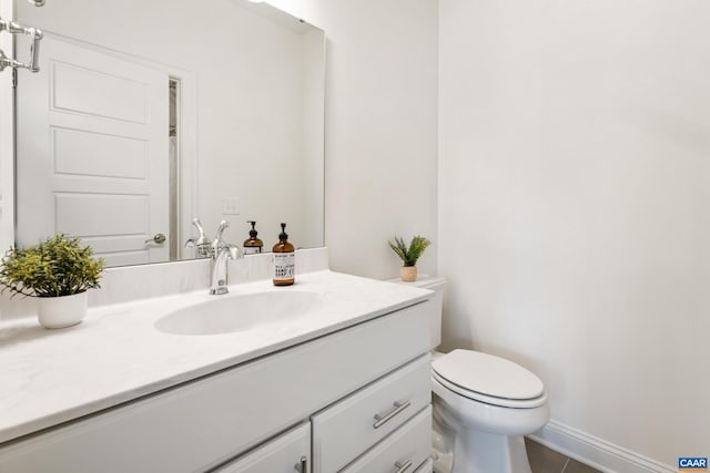 bathroom with vanity, toilet, tile patterned floors, and baseboards