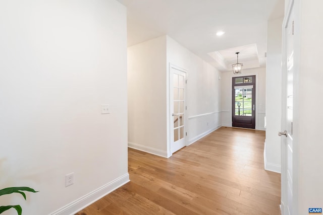 entrance foyer featuring a raised ceiling, baseboards, light wood-type flooring, and recessed lighting