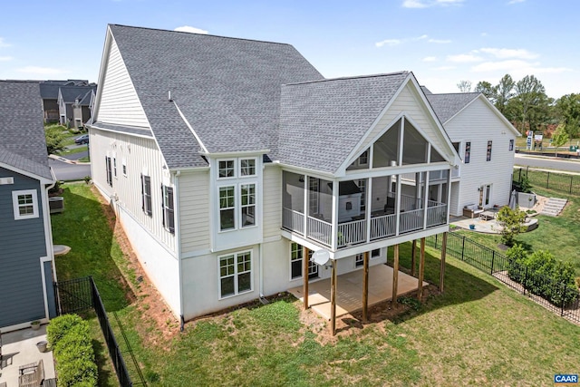 rear view of property with a patio, a sunroom, and a shingled roof