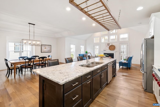kitchen featuring a sink, appliances with stainless steel finishes, an island with sink, healthy amount of natural light, and recessed lighting