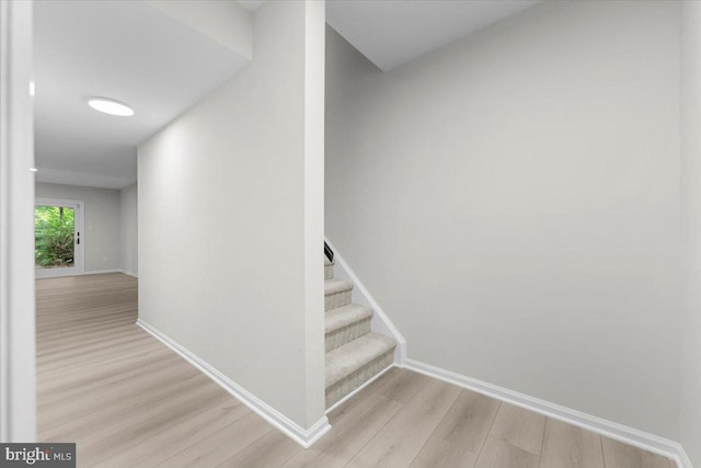 stairs with wood finished floors and baseboards