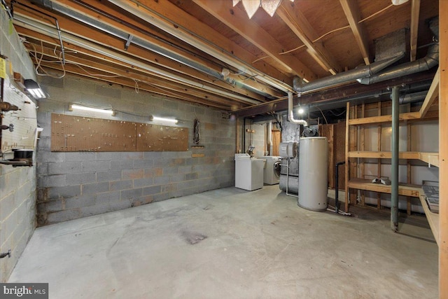 unfinished basement with water heater, washer and dryer, and concrete block wall