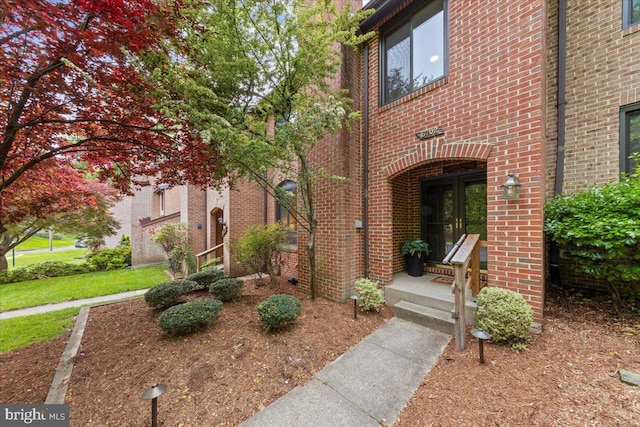 view of exterior entry with brick siding