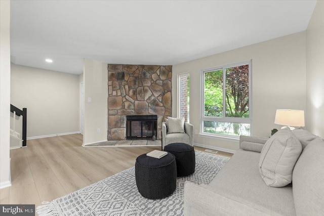 living room with baseboards, wood finished floors, and a fireplace