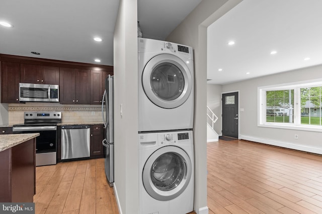 9 Queens Bridge Rd, Levittown, PA 19057 - laundry area with stacked washing machine and dryer, light wood-style floors, recessed lighting, and baseboards