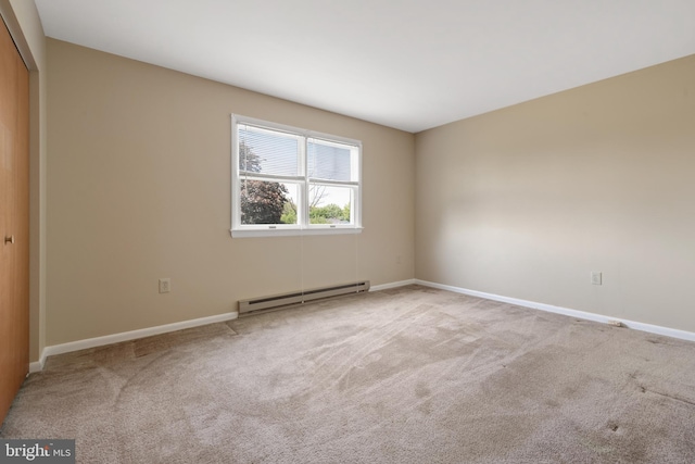 carpeted empty room with a baseboard radiator and baseboards