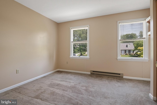empty room featuring baseboard heating, carpet floors, and baseboards