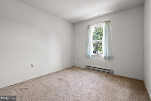 carpeted spare room with a baseboard radiator and baseboards