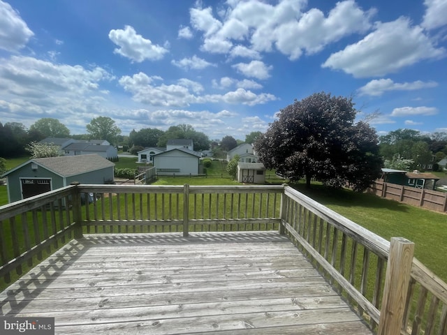 wooden deck with a storage unit, an outbuilding, and a residential view