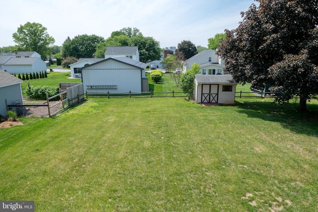 view of yard with an outdoor structure, a storage unit, and a residential view