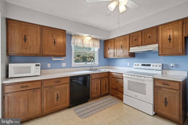 kitchen with white appliances, under cabinet range hood, a sink, and brown cabinets