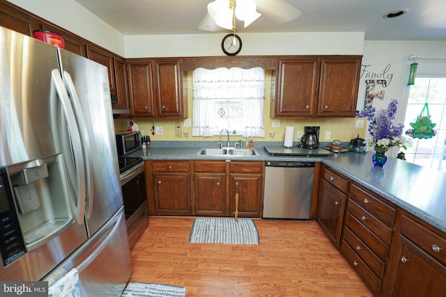 117 Mimosa Dr, Cambridge, MD 21613 - kitchen with stainless steel appliances, a sink, light wood finished floors, ceiling fan, and dark countertops