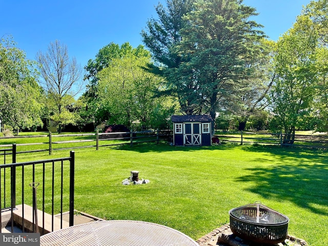 8117 Glendale Dr, Frederick, MD 21702 - fenced yard with a fire pit, a storage unit, and view of wooded area