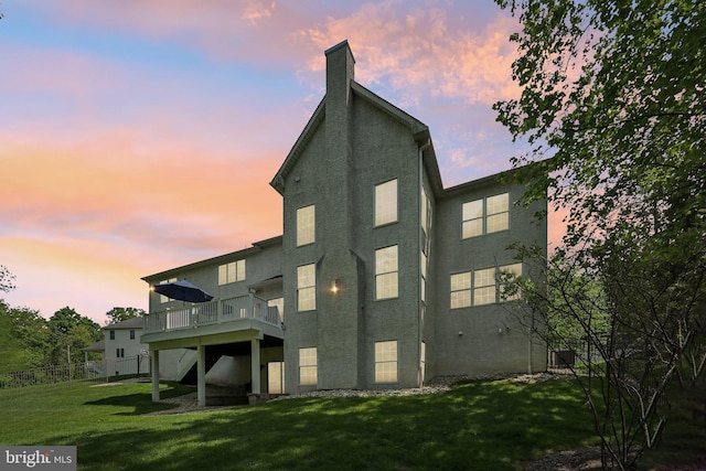 1311 Meadowbrook Ct, Jenkintown, PA 19046 - back of house at dusk with stucco siding, a deck, a chimney, and a yard