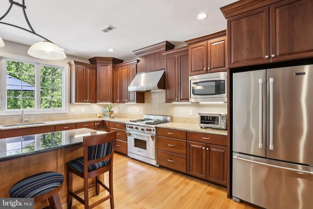 1311 Meadowbrook Ct, Jenkintown, PA 19046 - kitchen with high end appliances, extractor fan, a sink, light wood-style floors, and light stone counters