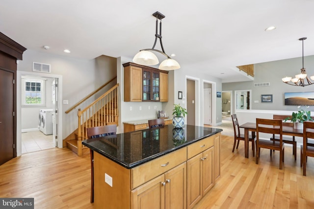 1311 Meadowbrook Ct, Jenkintown, PA 19046 - kitchen featuring washing machine and clothes dryer, light wood finished floors, a chandelier, glass insert cabinets, and a kitchen island