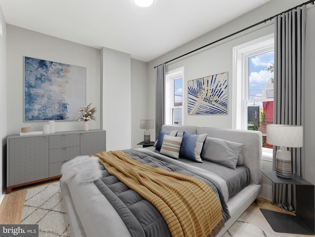 bedroom featuring multiple windows and light wood-style flooring