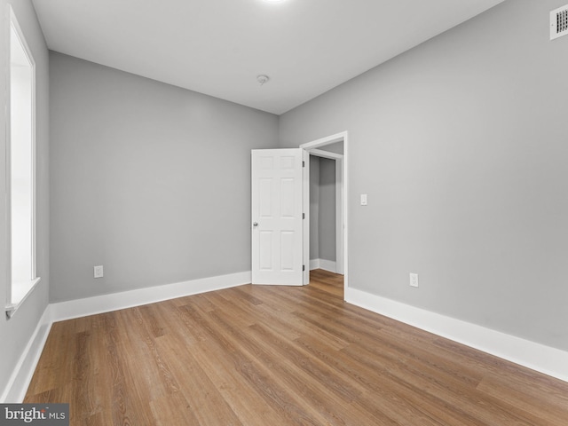 empty room featuring wood finished floors and baseboards