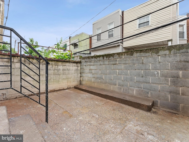 view of patio with fence and stairs