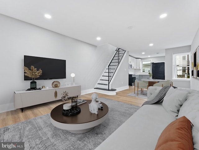 living room featuring light wood-style floors, stairway, recessed lighting, and baseboards