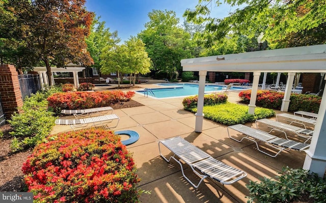 20301 Beechwood Ter Unit 203, Ashburn, VA 20147 - community pool featuring a patio area and view of scattered trees