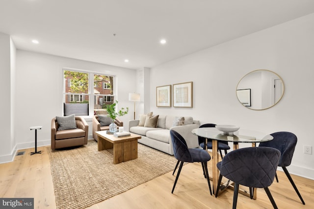 living room featuring light wood-type flooring, recessed lighting, and baseboards