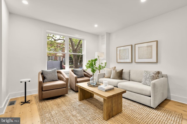 living room with light wood-style floors, recessed lighting, and baseboards